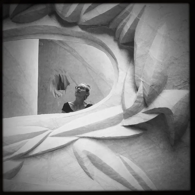 Nicholette Jean reflected within a large sculptural black and white artwork